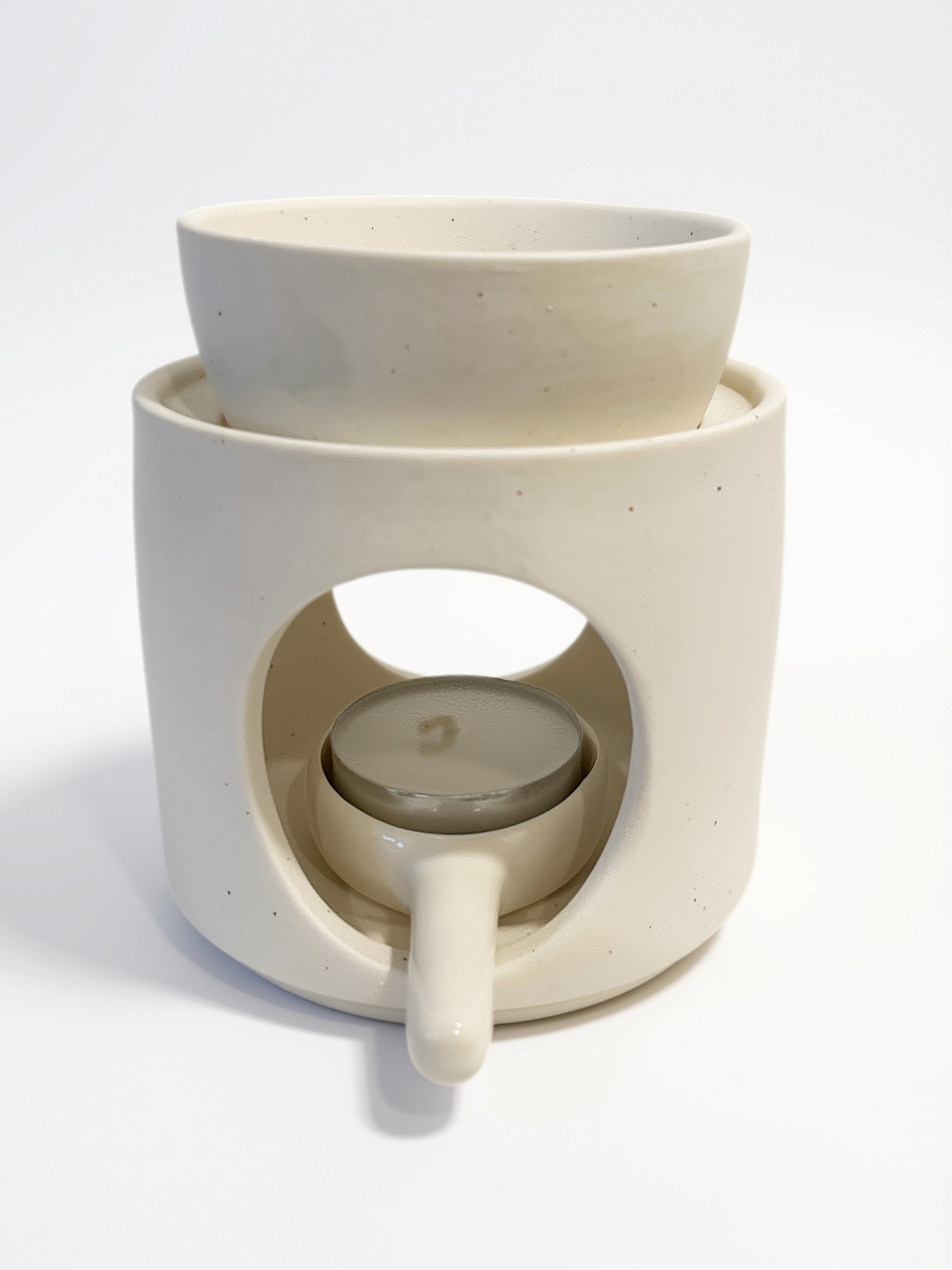 Burner de cerámica CHIE en tono marfil para wax melts, con cuenco superior y vela de té en la base.